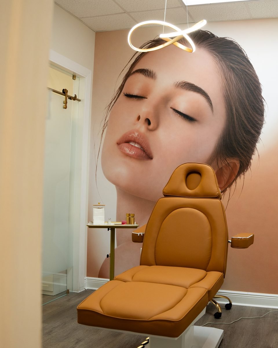 Second treatment room at The Edit with a caramel treatment chair and a mural of glowing, rested skin